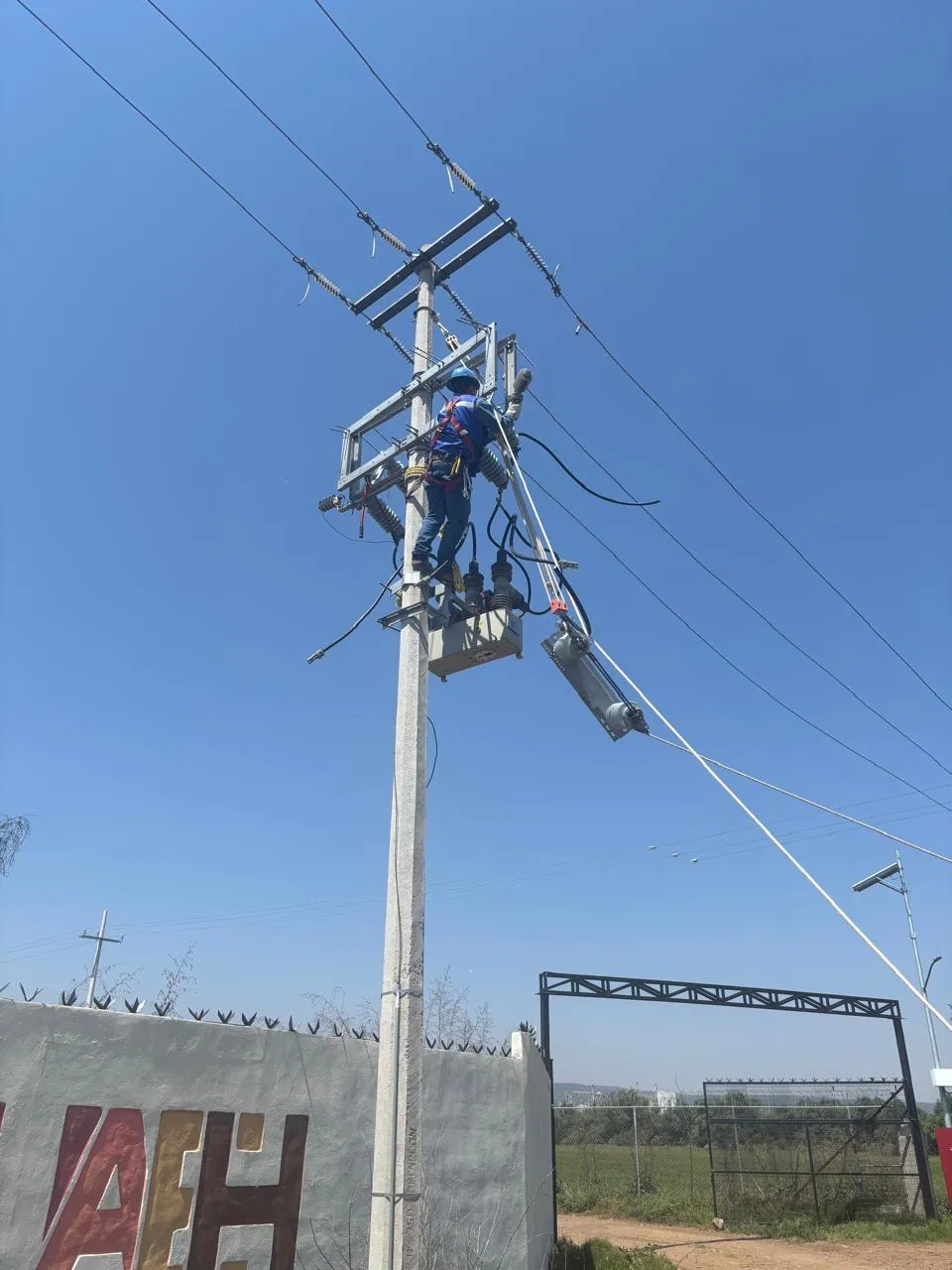 Técnico realizando mantenimiento en una línea de media tensión